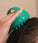 Woman massaging scalp with Neofollics scalp massaging shampoo brush