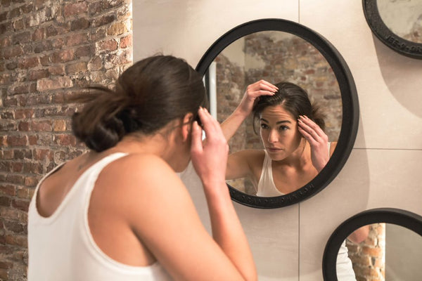 Woman checking hair in the mirror
