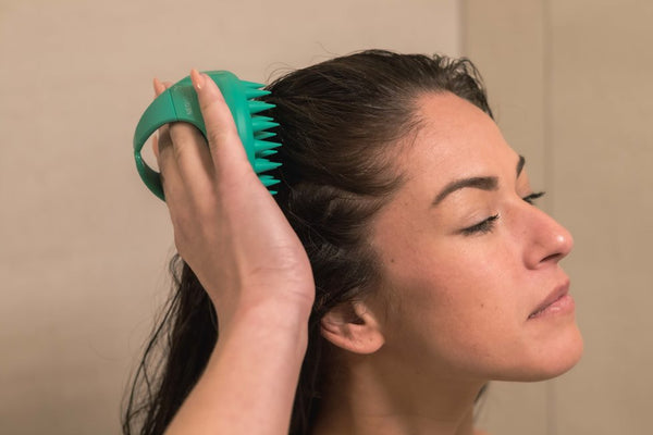 Woman using neofollics scalp brush