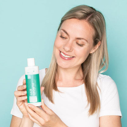Woman holding the Neofollics Hair Growth Stimulating Conditioner