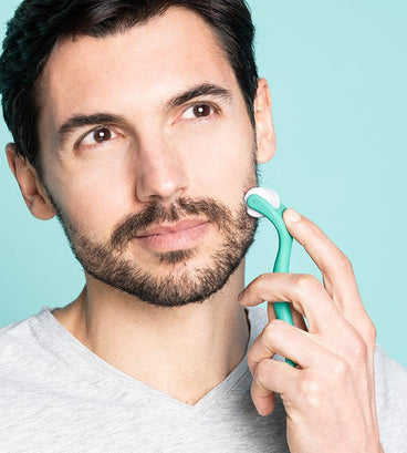 Man rolling neofollics beard growth roller on cheek