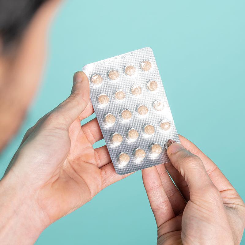 Man holding neofollics hair growth supporting tablets