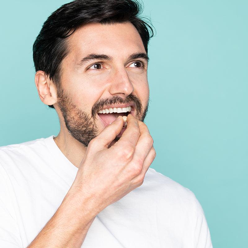 Man taking a neofollics beard growth supporting tablet