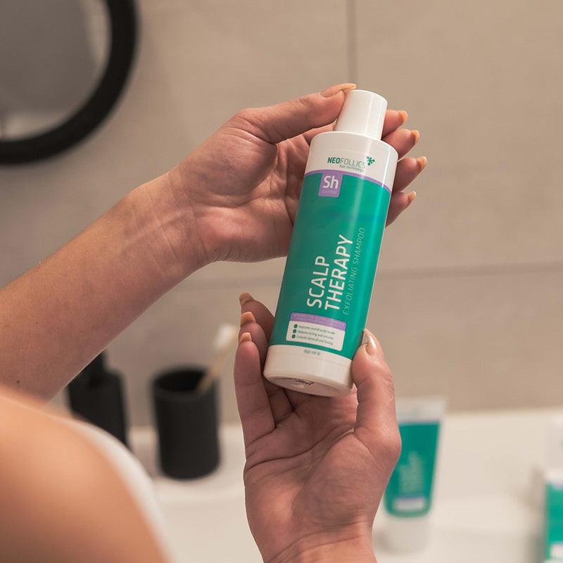 Woman holding the Nefollics scalp therapy exfoliating shampoo