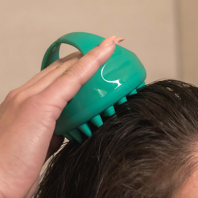 Woman massaging scalp with Neofollics scalp massaging shampoo brush