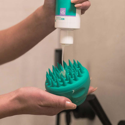 Woman applying scalp shampoo on Neofollics scalp massaging shampoo brush